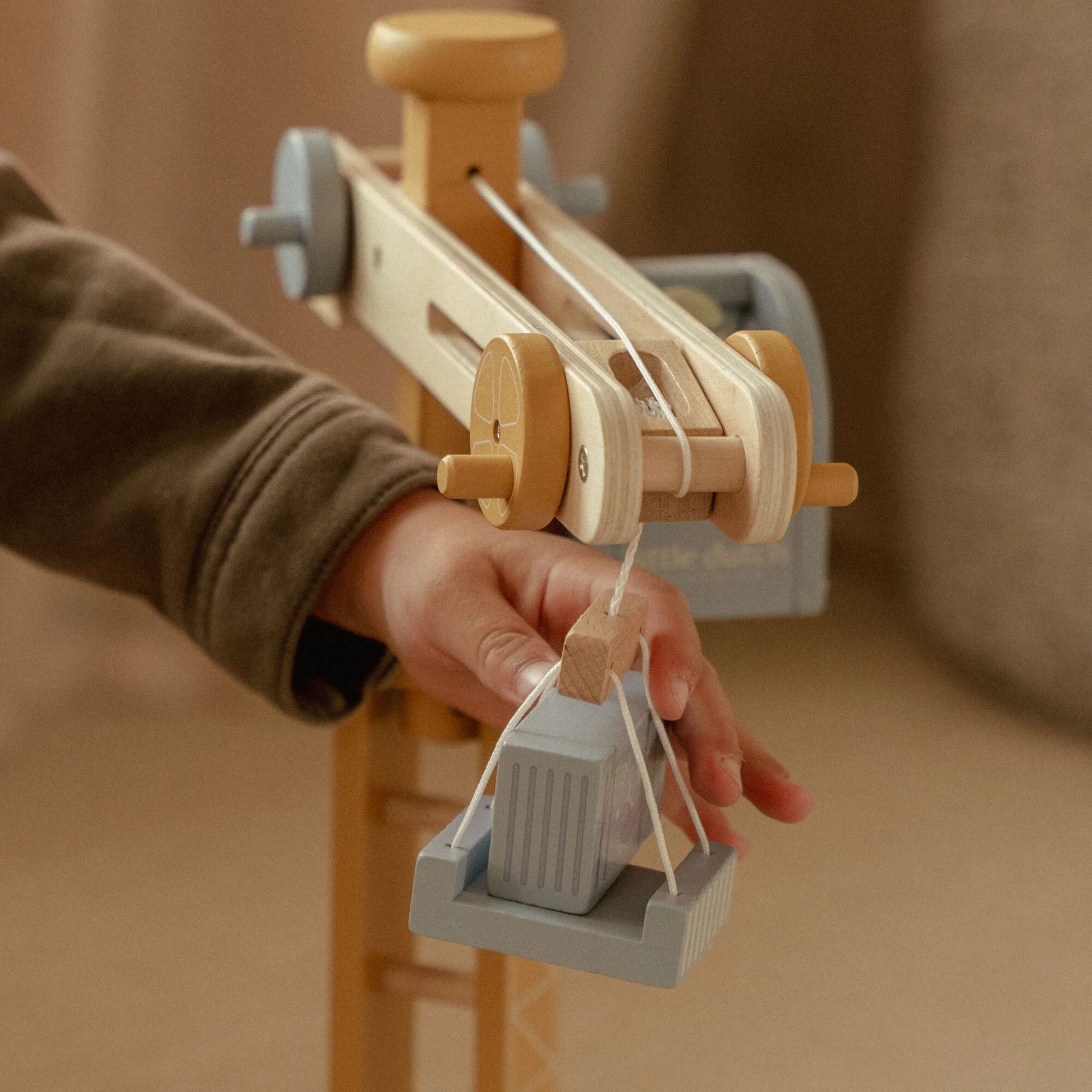 Wooden toy crane with a hand operating it