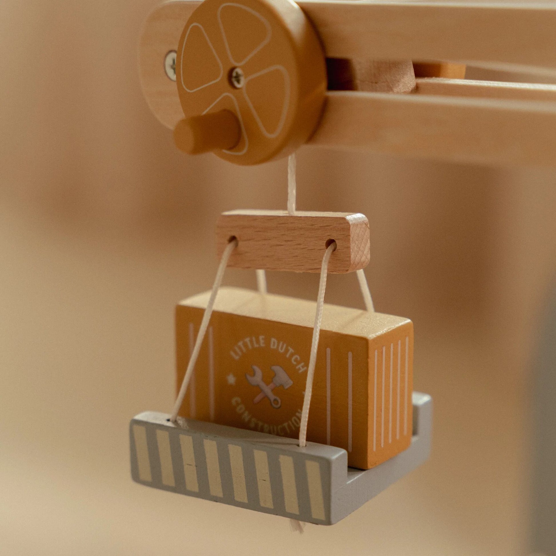 Wooden toy with a crate and construction box on a beige background