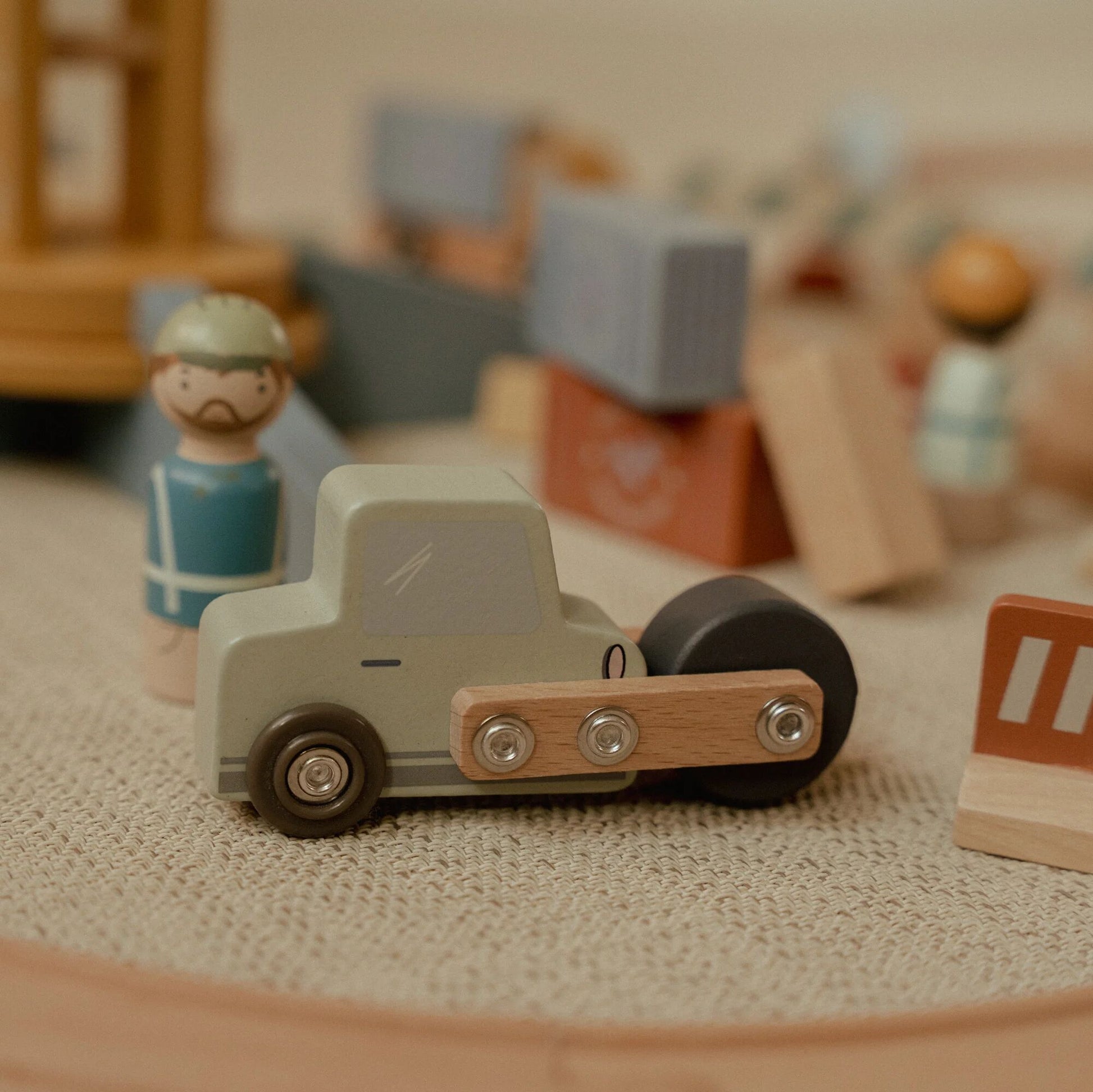 Wooden toy truck on a textured surface with blurred background