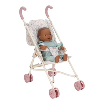 Doll in a metal stroller with floral canopy on a white background